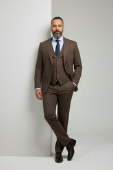 Man wearing tailored brown three-piece suit with vest and tie, ideal for weddings or business.